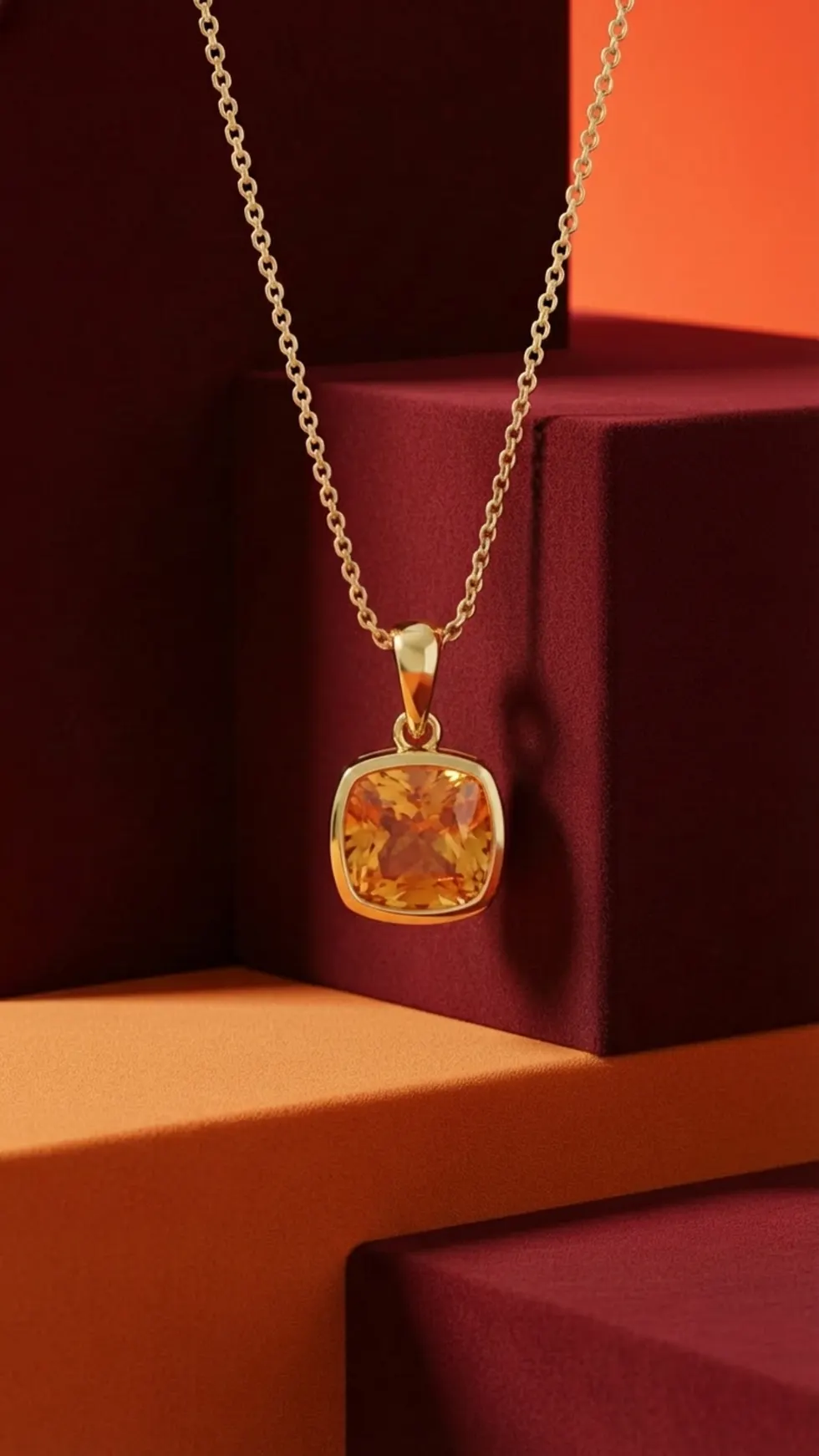 AI jewelry photo: citrine gold pendant necklace draped over burgundy suede display blocks with warm editorial lighting